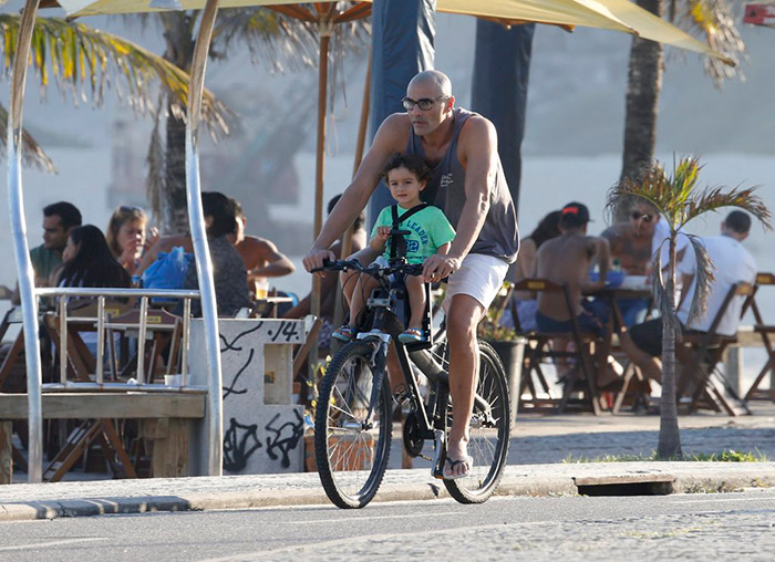 Com o filho na garupa, Luciano Szafir pedala pelo Rio