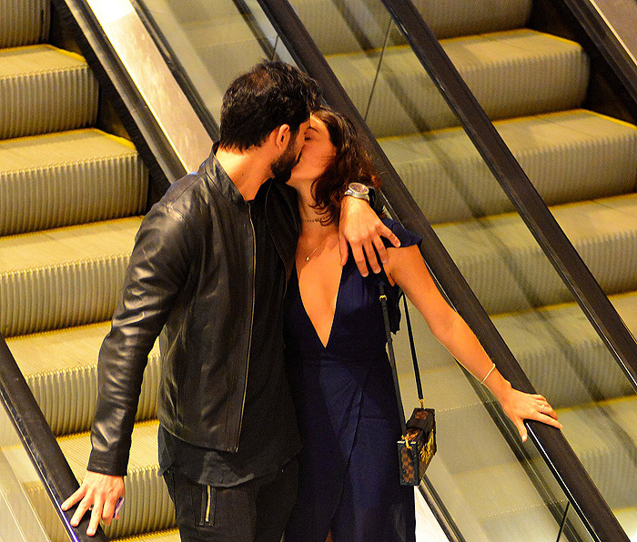 O casal namorando na escada rolante