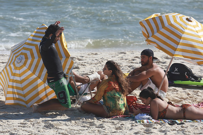 Com look colorido, Deborah Secco vai à praia com namorado