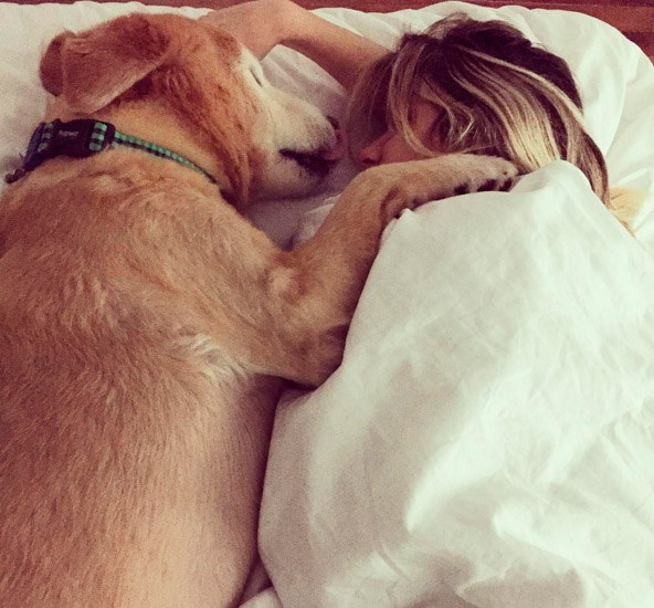 Na cama, Giovanna Ewbank recebe carinho do cachorro