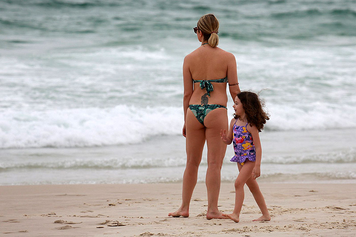 Letícia Spiller observa o mar com a filha