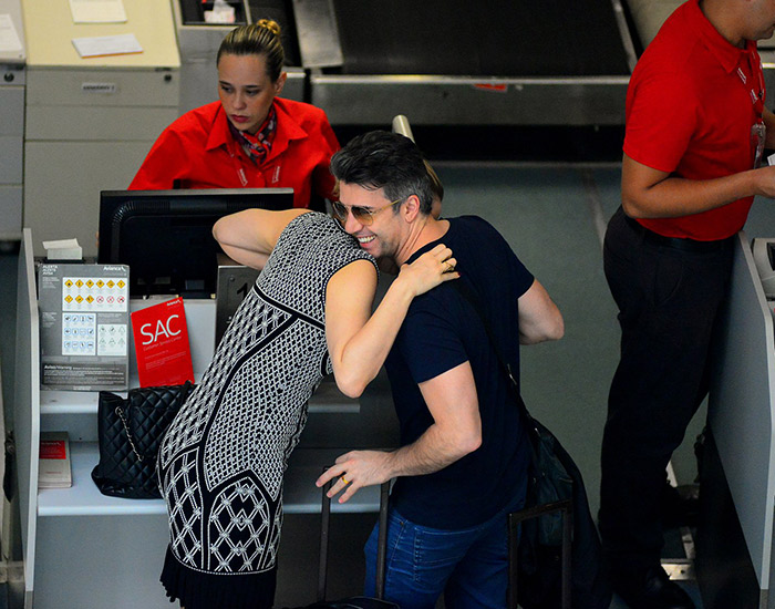 Cláudia Raia e marido trocam risadas em aeroporto