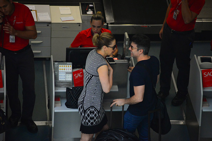 Cláudia Raia e marido trocam risadas em aeroporto