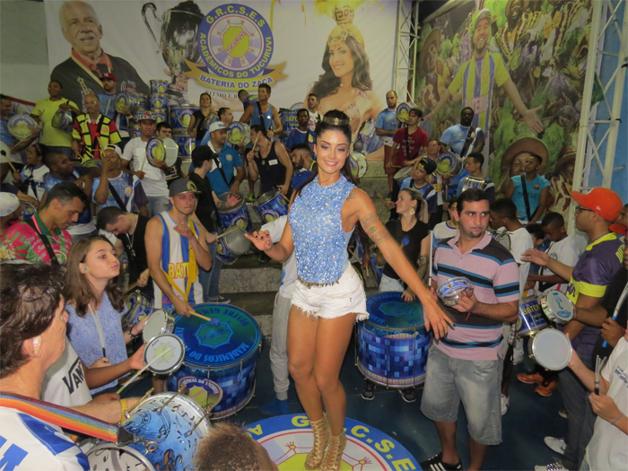 De shortinho, Aline Riscado toca surdo em escola de samba