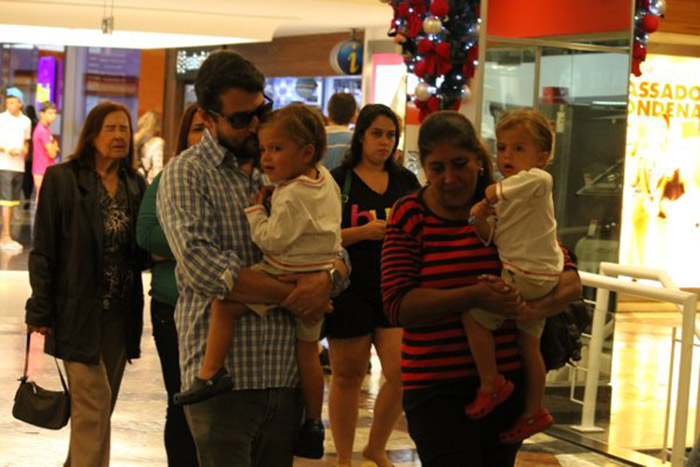 Marcelo Serrado passeia com os gêmeos em shopping na Gávea