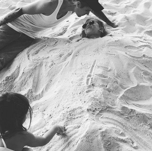 Justin Bieber enterra seu irmão na areia em brincadeira 