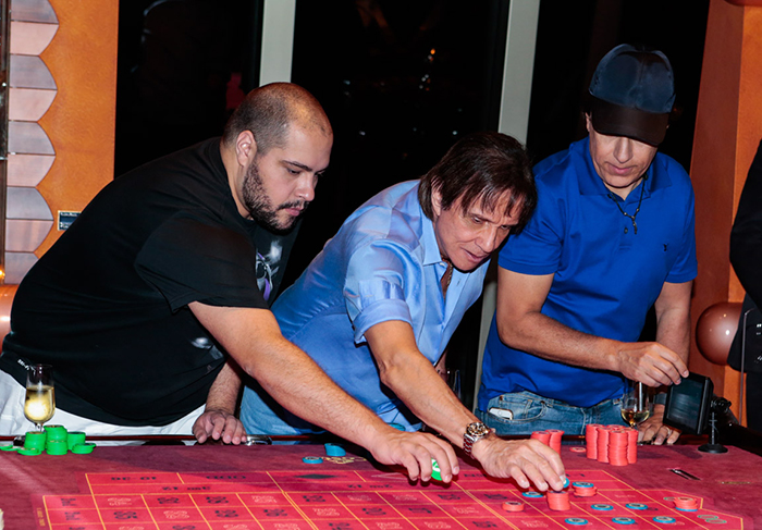 Tiago Abravanel, Roberto Carlos e Tom Cavalcante, focados na mesa do jogo