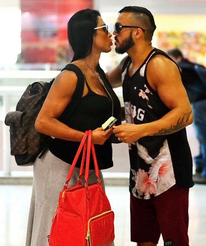 Belo e Gracyanne Barbosa trocam beijinhos em aeroporto