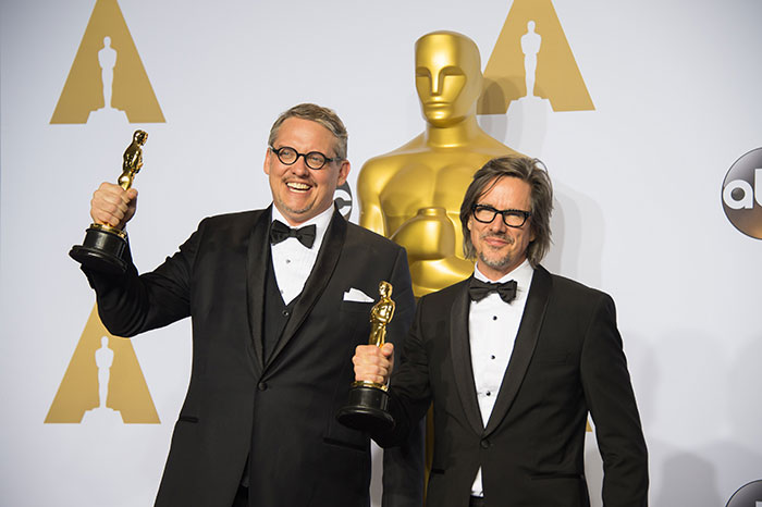 Adam McKay e Charles Randolph posam com o Oscar de melhor roteiro adaptado em A grande Aposta