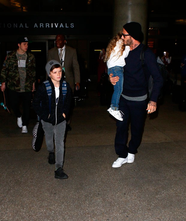 Papai! David Beckham chega em Los Angeles com Harper no colo