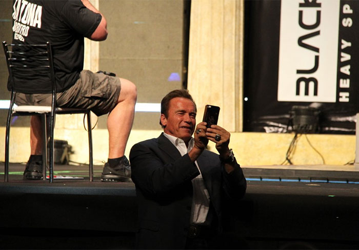 Completamente à vontade, Schwarzenegger chegou a mexer em seu aparelho celular, enquanto curtia a feira