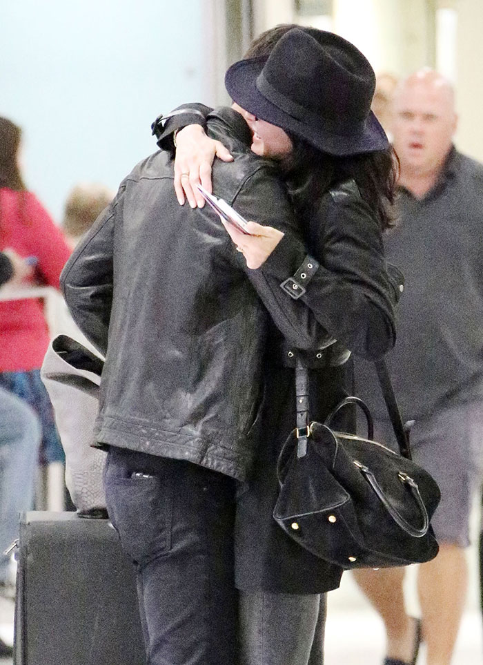 Courteney Cox dá beijão no noivo em aeroporto