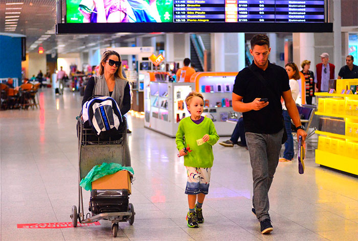 Danielle Winits embarca com filho e namorado em aeroporto 
