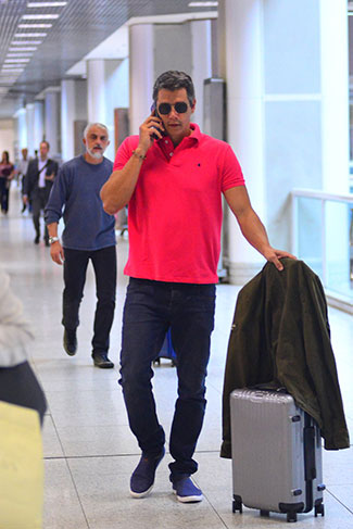 Márcio Garcia não desgrudou do celular no aeroporto