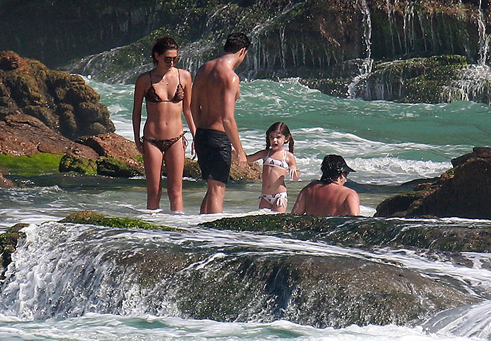 Cauã Reymond se diverte com a namorada e a filha na praia
