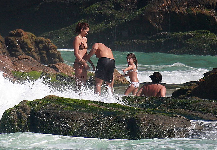 Cauã Reymond se diverte com a namorada e a filha na praia