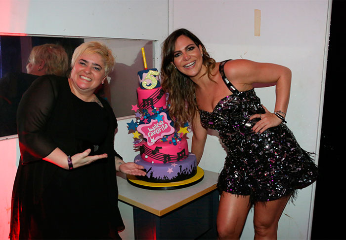 Carol Sampaio posa para fotos com amiga e bolo que ganhou, pelo aniversário do evento