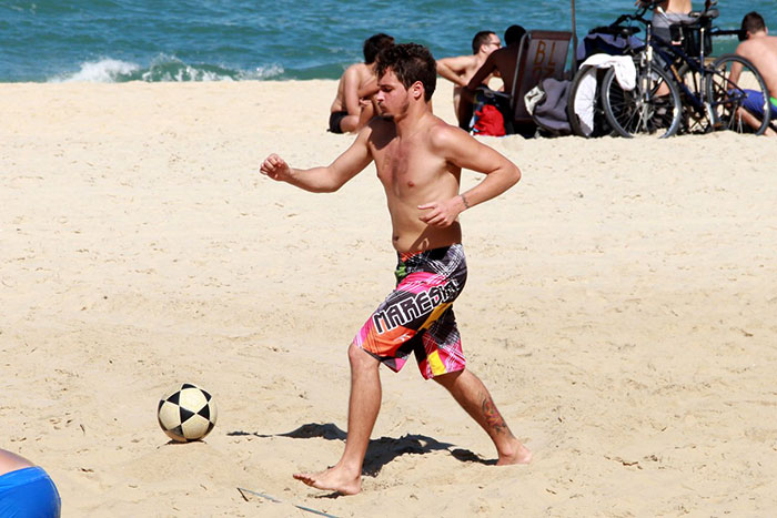 Sem camisa, Felipe Dylon se diverte com amigos na praia