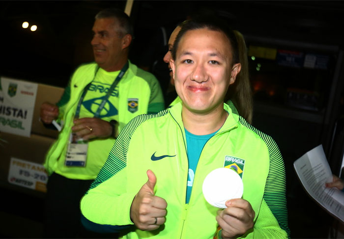 Simpático, atirador esportivo posou para fotos, com a medalha de prata nas mãos