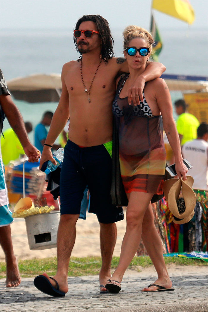 Danielle Winits e André Gonçalves trocam beijos na praia