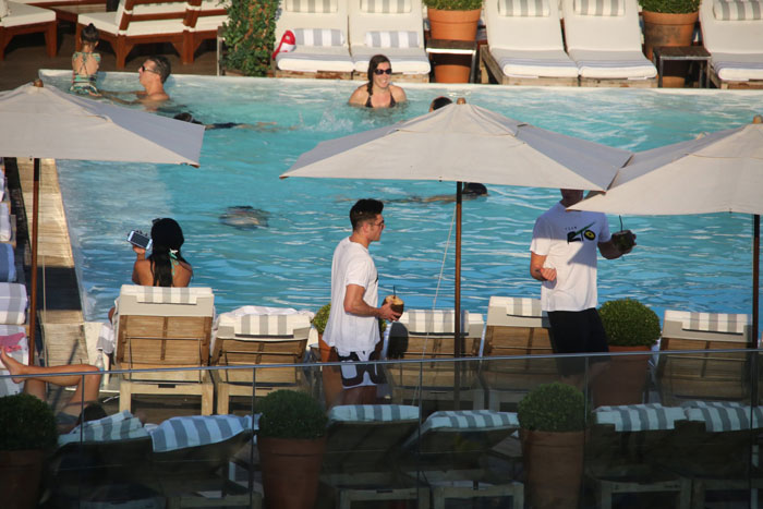 Zac Efron curte piscina e água de coco no Rio 