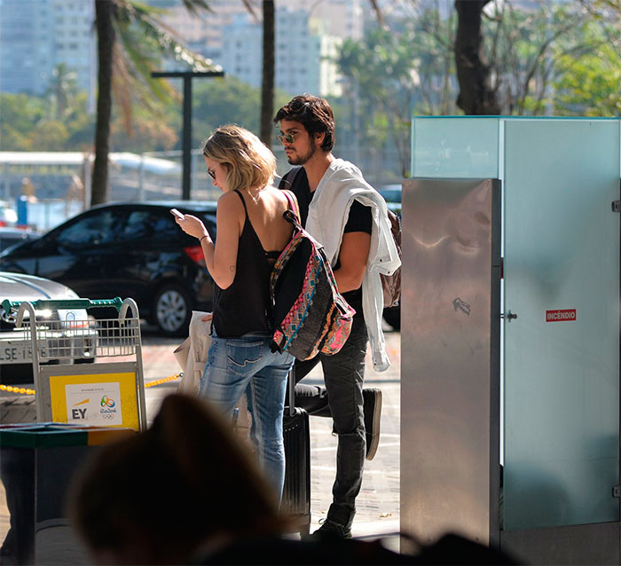 Rodrigo Simas acena para fotógrafo ao desembarcar no Rio