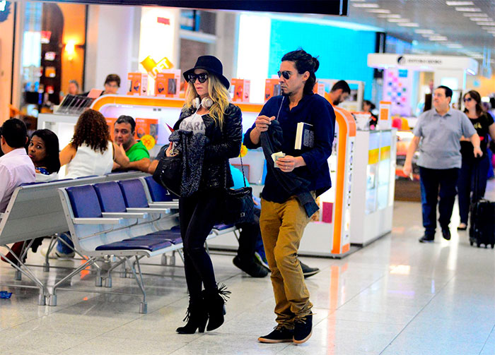 Dani Winits e André Gonçalves circulam por aeroporto no Rio