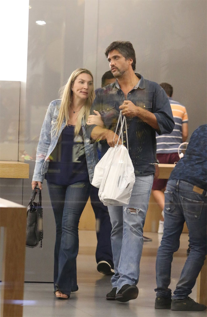 De braços dados, Léo Chaves e a esposa passeiam por shopping