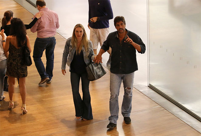 De braços dados, Léo Chaves e a esposa passeiam por shopping