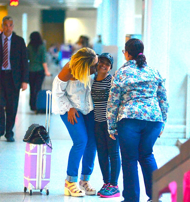 Belo e Gracyanne Barbosa se beijam na saída de aeroporto carioca