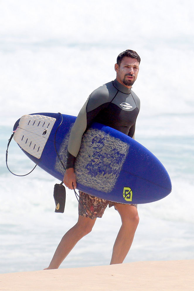 Cauã Reymond acena para fotógrafo após curtir o mar carioca