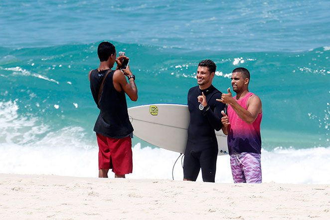 Cauã Reymond surfa e tira fotos com fãs no Rio