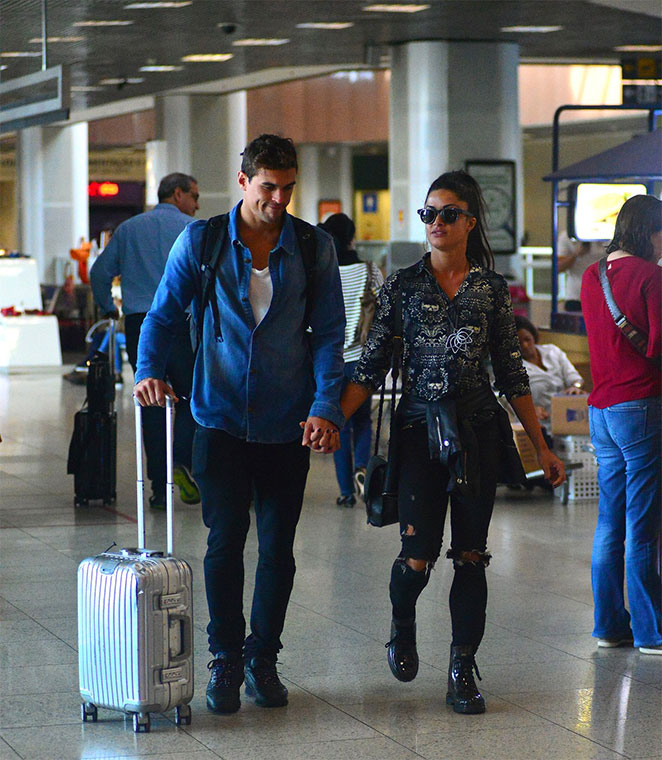 Felipe e Aline Riscado andam de mãos dadas em aeroporto