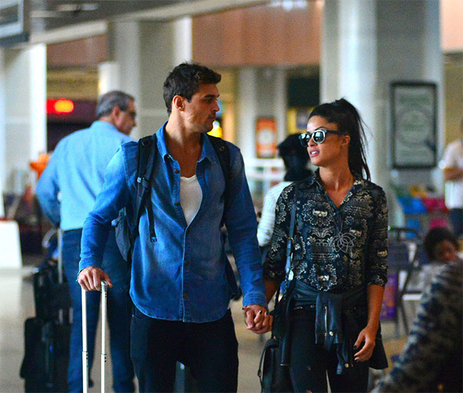 Felipe e Aline Riscado andam de mãos dadas em aeroporto