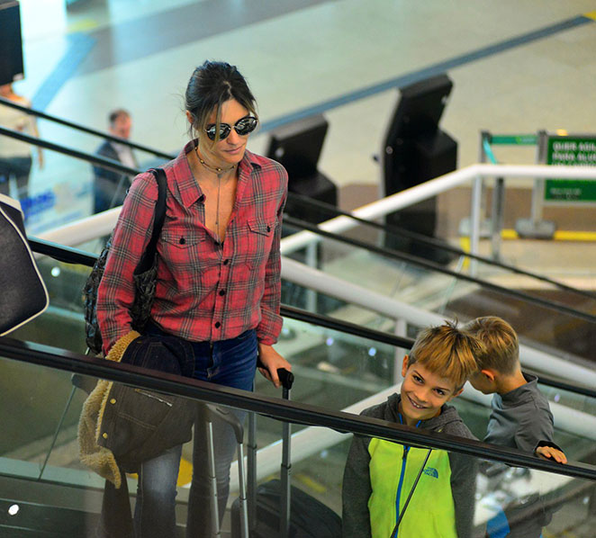 Fernanda Lima embarca com gêmeos em aeroporto