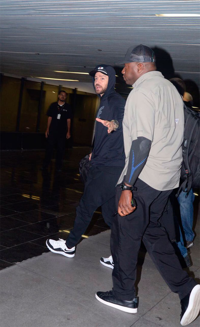 Justin Timberlake acena para os fotógrafos ao deixar o País