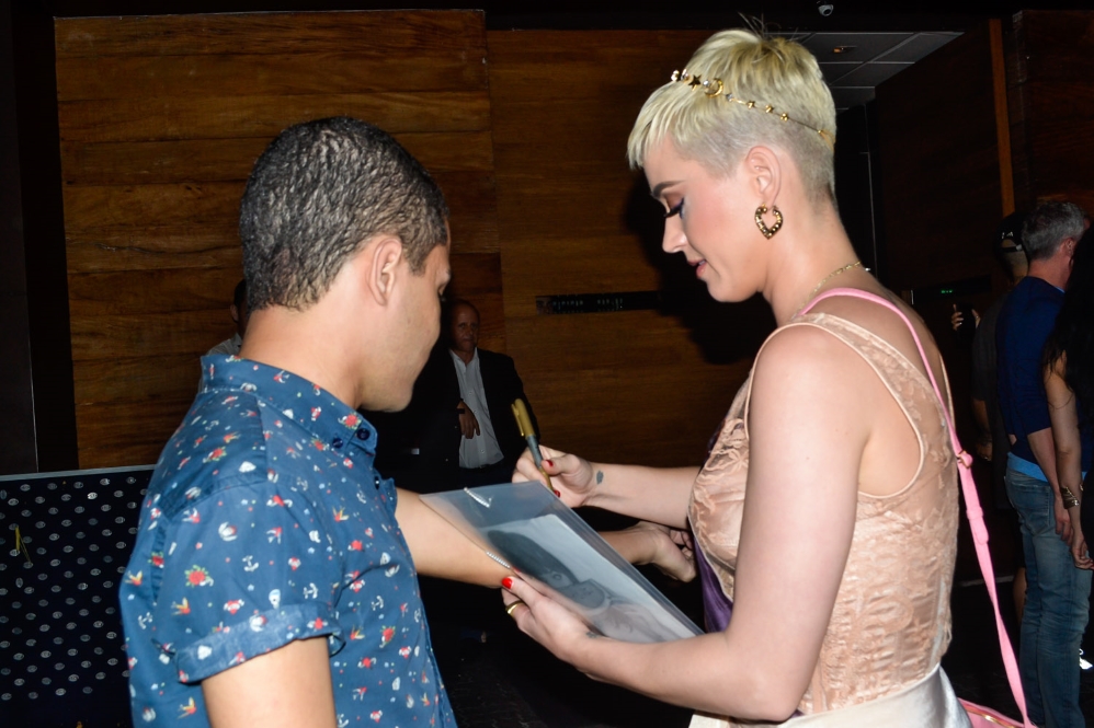 Katy Perry atende fãs ao sair de restaurante