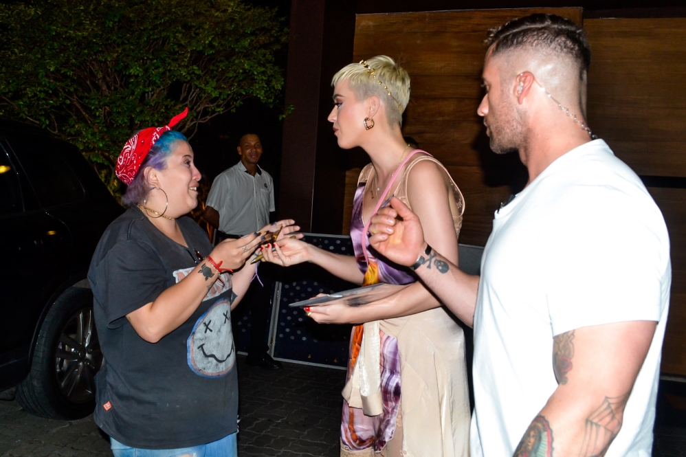 Katy Perry atende fãs ao sair de restaurante