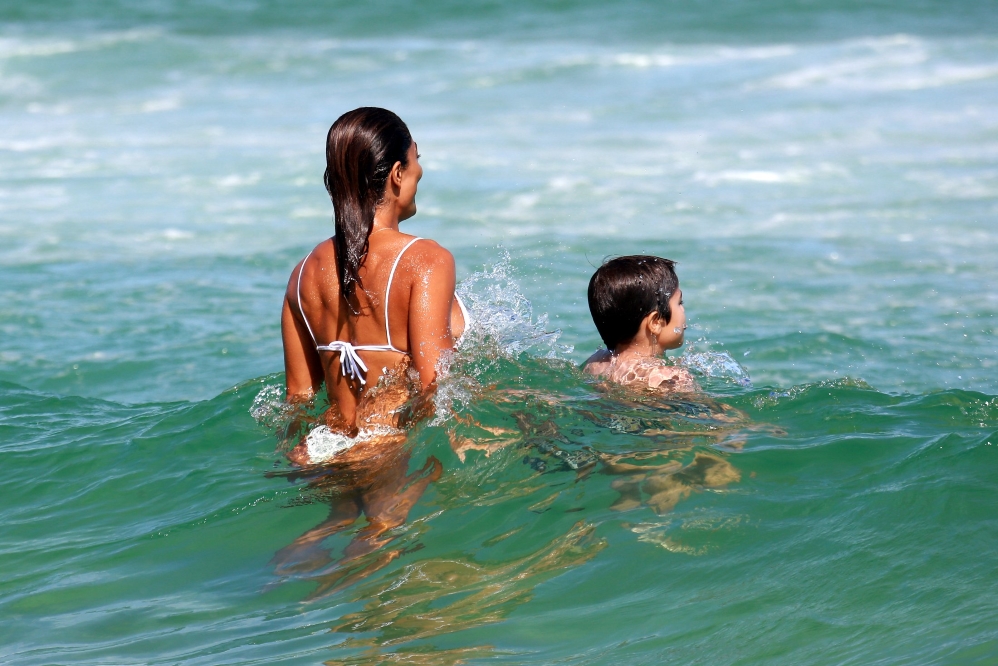 De biquíni branco, Juliana Paes curte praia com a família