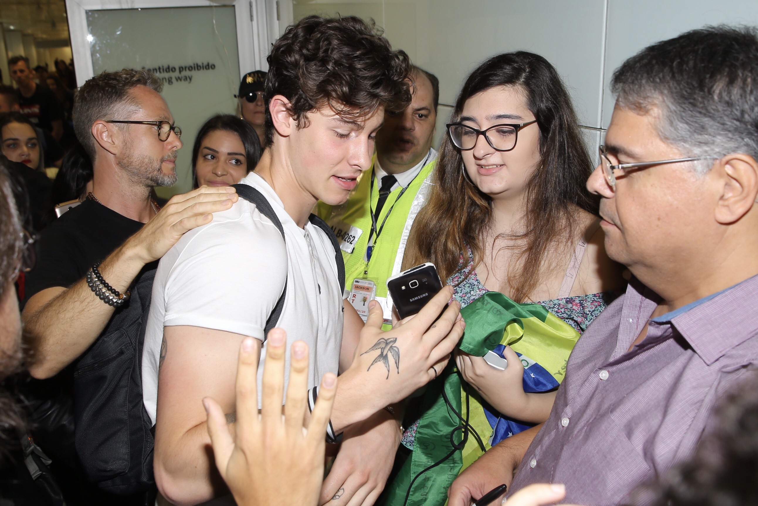 Shawn Mendes esbanja simpatia e posa com fãs ao chegar no Brasil