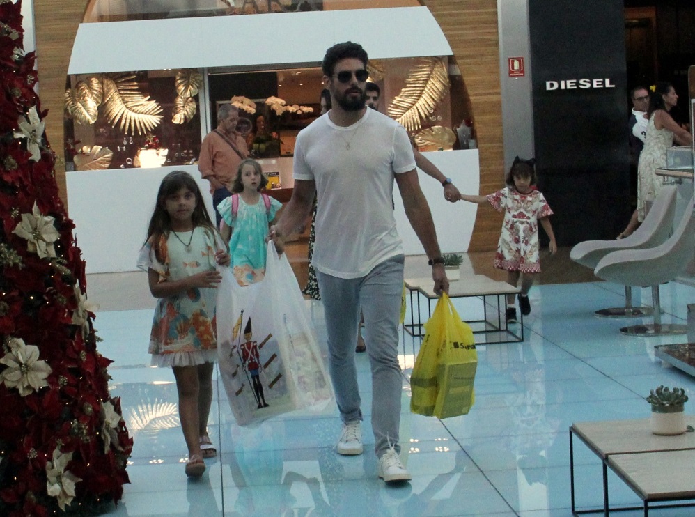 Cauã Reymond faz compras com filha e namorada