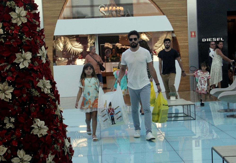 Cauã Reymond faz compras com filha e namorada