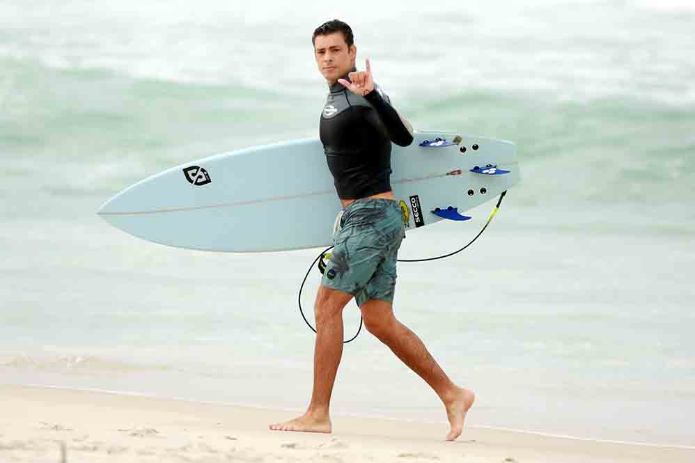 Cauã Reymond surfa e leva caldo em praia do Rio de Janeiro