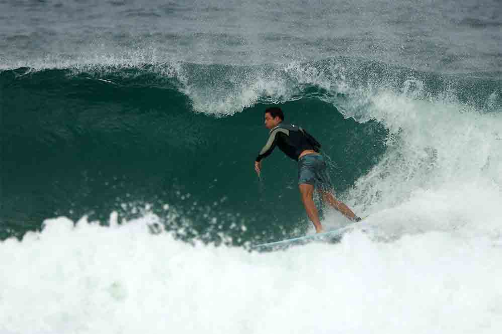 Cauã Reymond surfa e leva caldo em praia do Rio de Janeiro