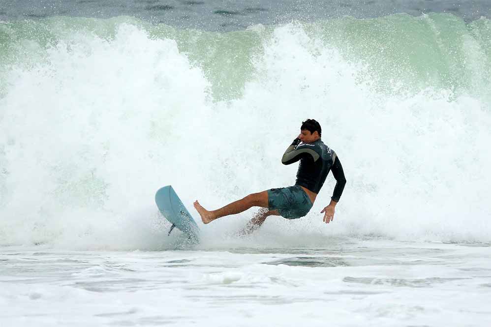 Cauã Reymond surfa e leva caldo em praia do Rio de Janeiro