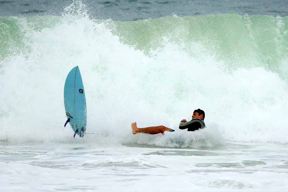 Cauã Reymond surfa e leva caldo em praia do Rio de Janeiro