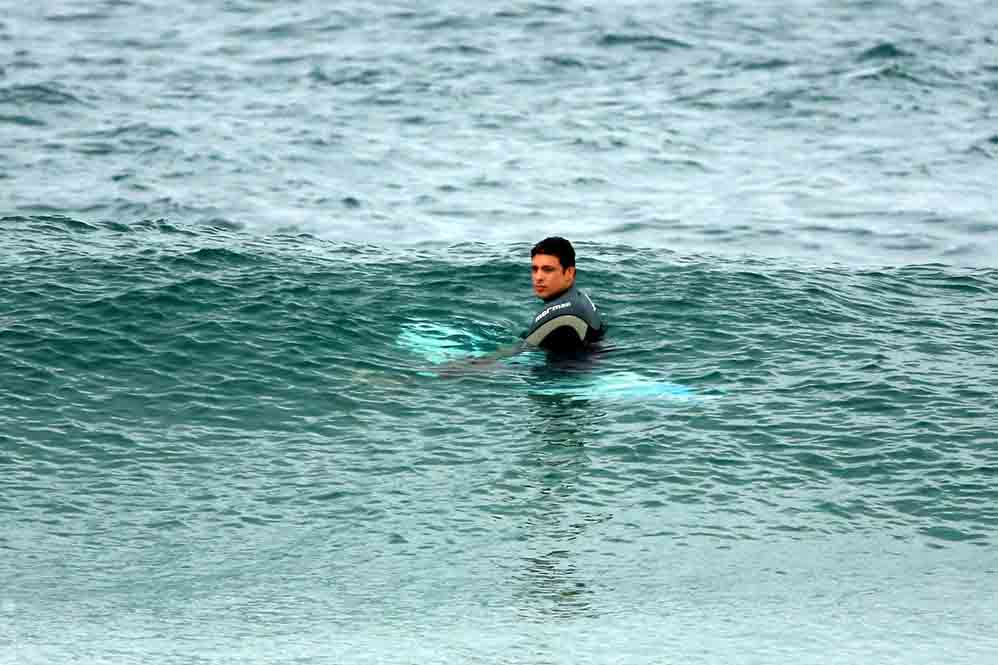 Cauã Reymond surfa e leva caldo em praia do Rio de Janeiro