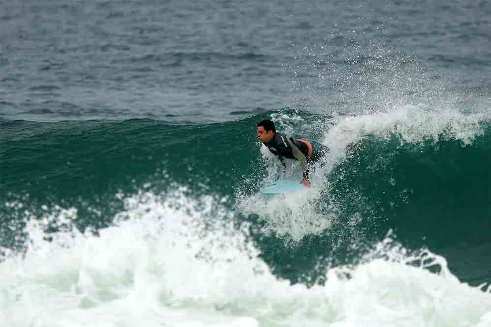 Cauã Reymond surfa e leva caldo em praia do Rio de Janeiro