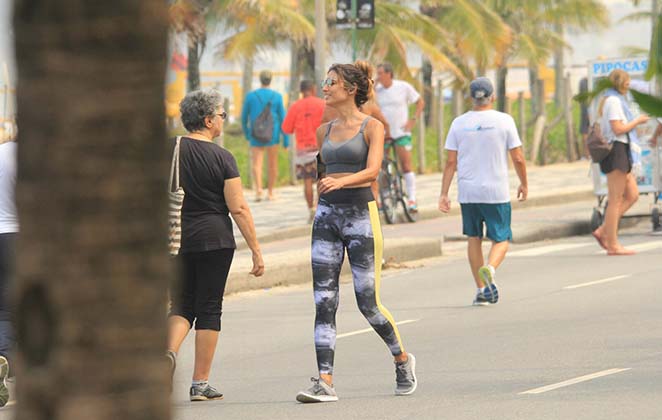 Patrícia Poeta caminha corridente pela orla do Leblon