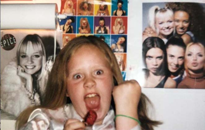 Adele enquanto criança ao redor de vários pôsteres das Spice Girls